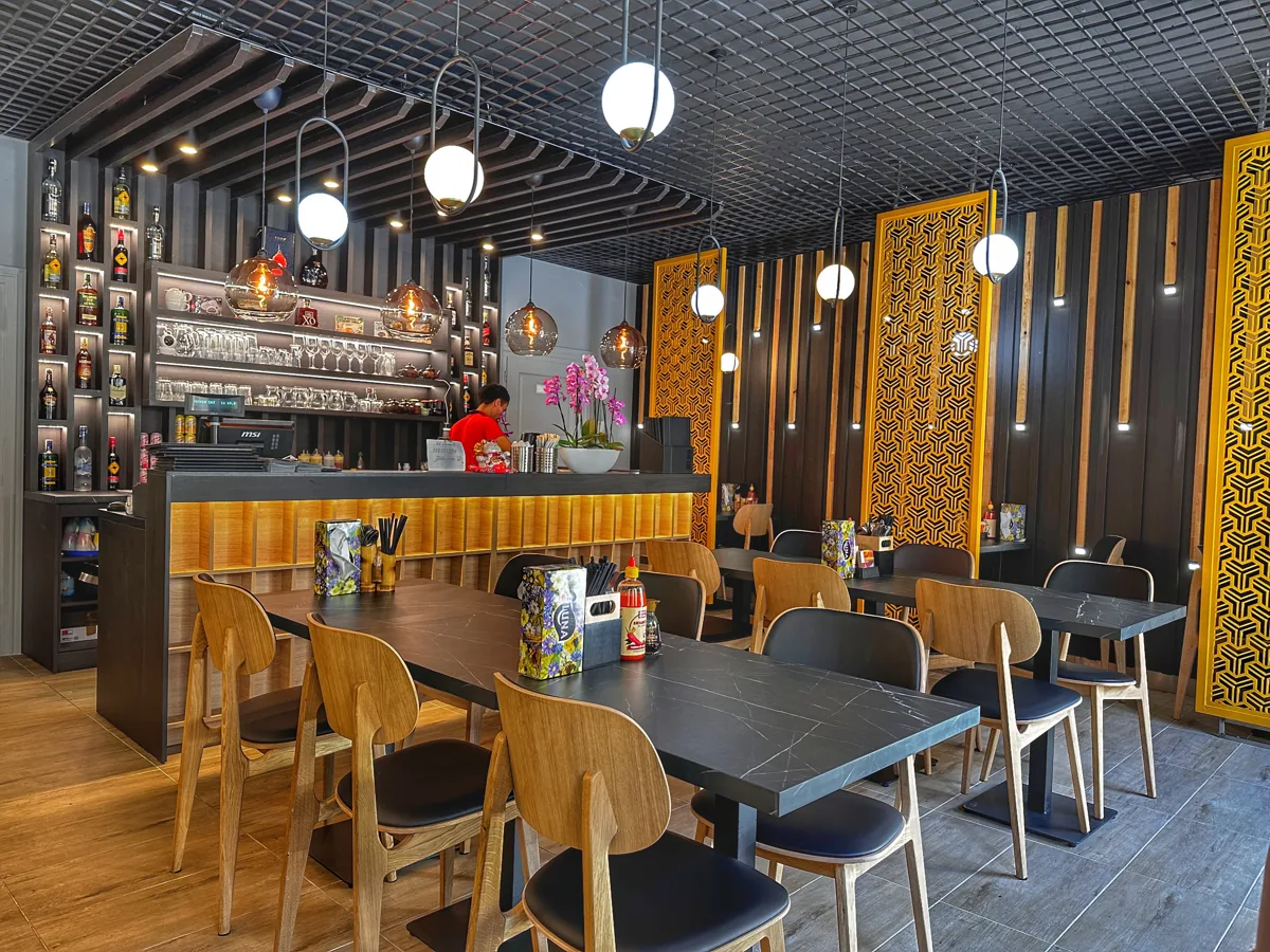 Interiér restaurace Deli Bowl se stoly a barem